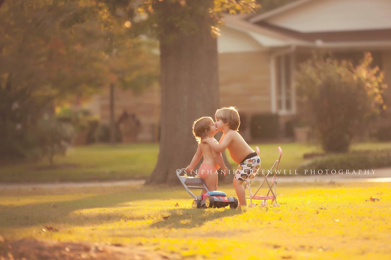 boy kissing girl siblings sunset toy lawn mower stroller southeast missouri photographer stephanie greenwell